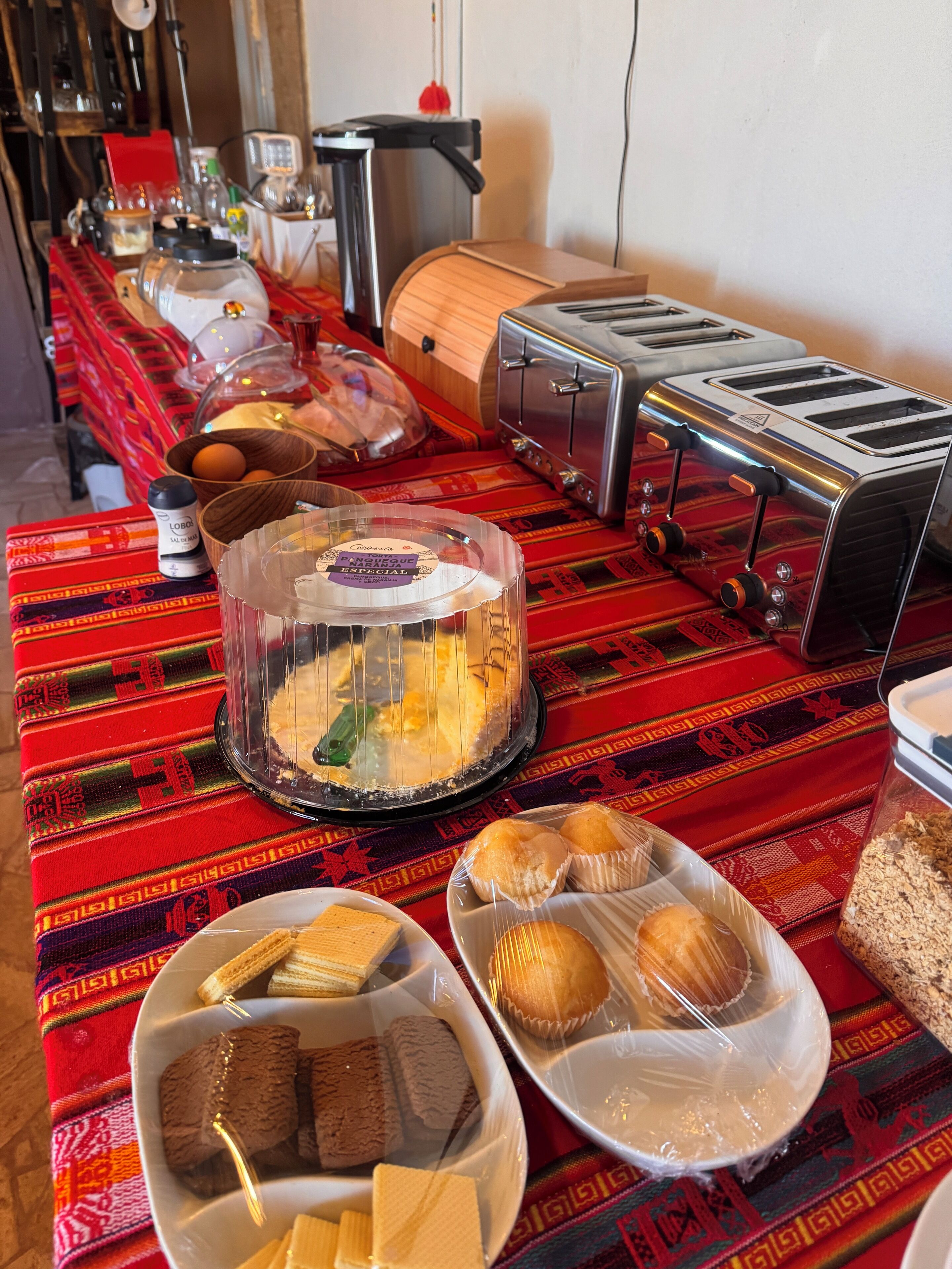 Un ricco buffet per la colazione con dolci, pane e un angolo caffè.