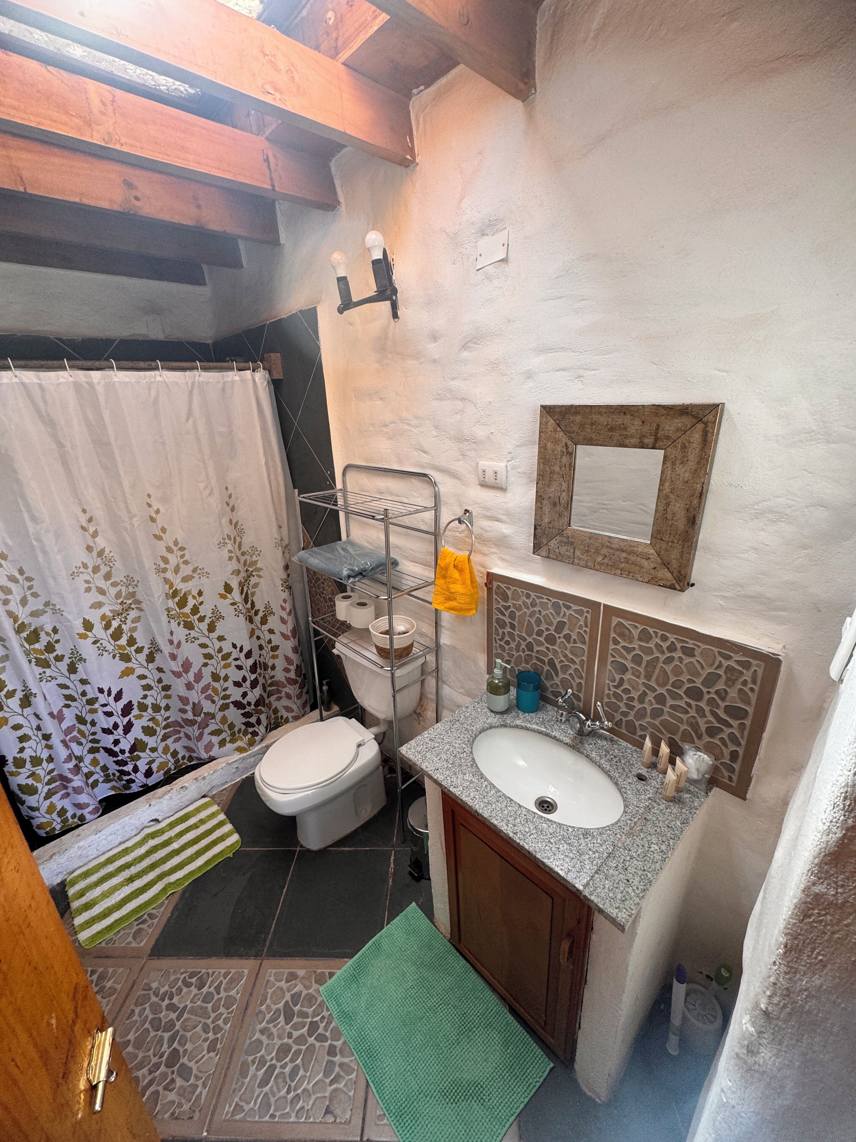 A compact bathroom with a toilet, sink, and shower area.
