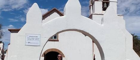 A white church with a bell tower and a cross on top.
