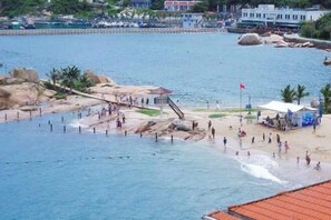 Eine Küstenlandschaft mit einem felsigen Strand, einer Pier und einer Flagge.