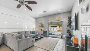 A modern living room with a grey sofa, a coffee table, and a ceiling fan. - Gorgeous Tranquil Desert Retreat (Desert Hot Springs)