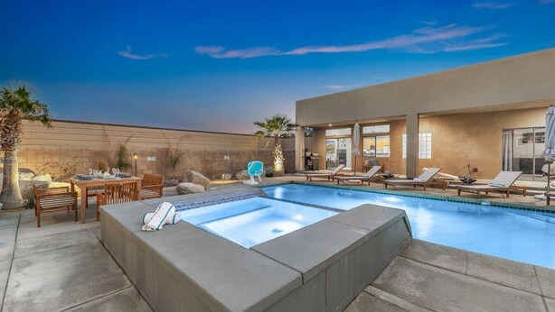 A pool area with lounge chairs, a hot tub, and a dining setup. - Gorgeous Tranquil Desert Retreat (Desert Hot Springs)