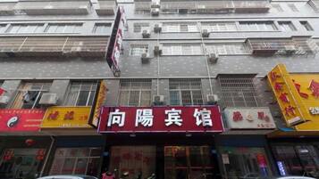 A multi-story building with a prominent red sign for a restaurant.