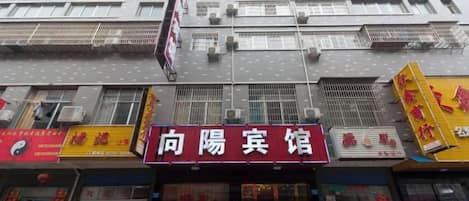 A multi-story building with a prominent red sign for a restaurant.
