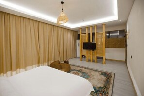 A modern bedroom with a large bed, a ceiling light, a television, and a decorative wall panel. - Jinsha Xibandao Hotel (Jinsha)