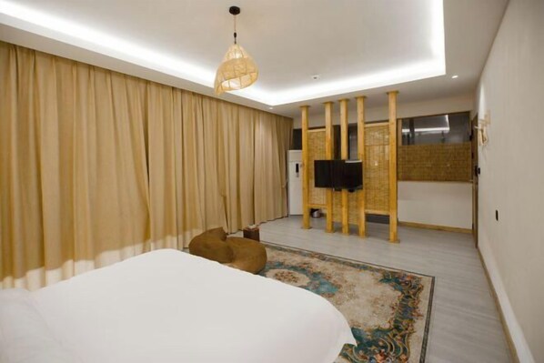 A modern bedroom with a large bed, a ceiling light, a television, and a decorative wall panel.