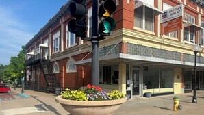 A street scene with a building labeled "The Property Shop" and a large planter with flowers.
