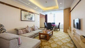 A living room with a sofa, coffee table, and a TV mounted on the wall. - Wanli Hotel (Chengdu Head Office) (Chengdu)