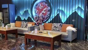 A modern lobby with a sofa set, a coffee table, and a decorative wall with a circular design. - Wanli Hotel (Chengdu Head Office) (Chengdu)