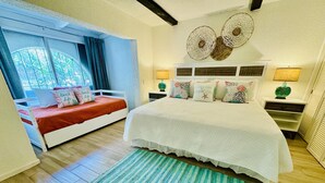 A bedroom with a bed, a window, and a nightstand.