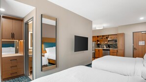 A hotel room with a bed, a desk, a mirror, and a kitchenette. - Candlewood Suites Chester Richmond by IHG (Chester)