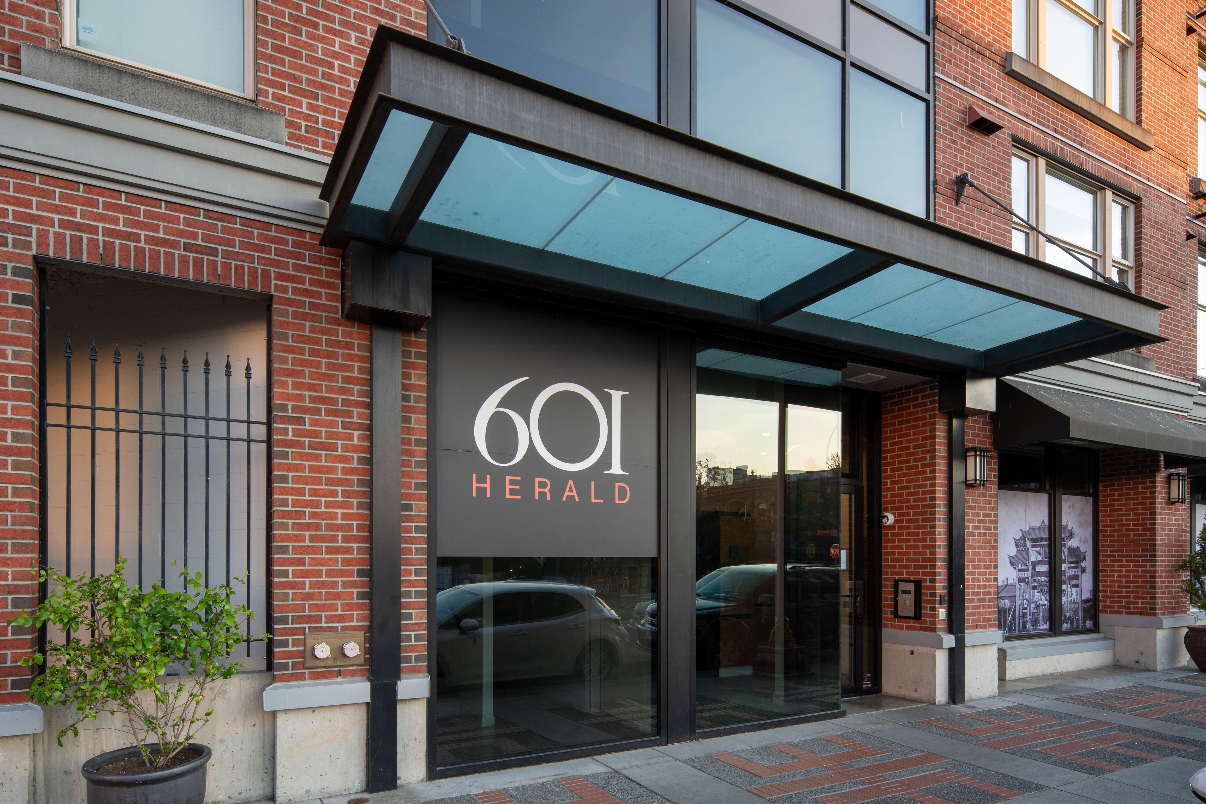 A building entrance with a glass door and a sign reading '601 Herald'.