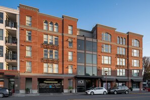 A multi-story building with a brick facade, large windows, and a modern entrance. - Bright Condo in Victoria's Trendy Old Town (Victoria North)