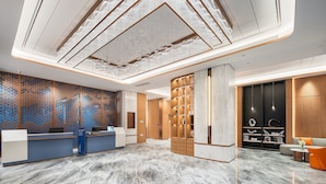 A modern hotel lobby with a reception desk, seating area, and decorative ceiling. - Holiday Inn Express Chengdu Shuangliu Airport by IHG (Chengdu)