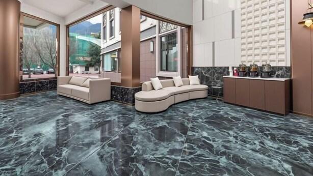 Eine moderne Lobby mit einer gebogenen Couch, einem Marmorboden und großen Fenstern mit Blick auf die Stadt.