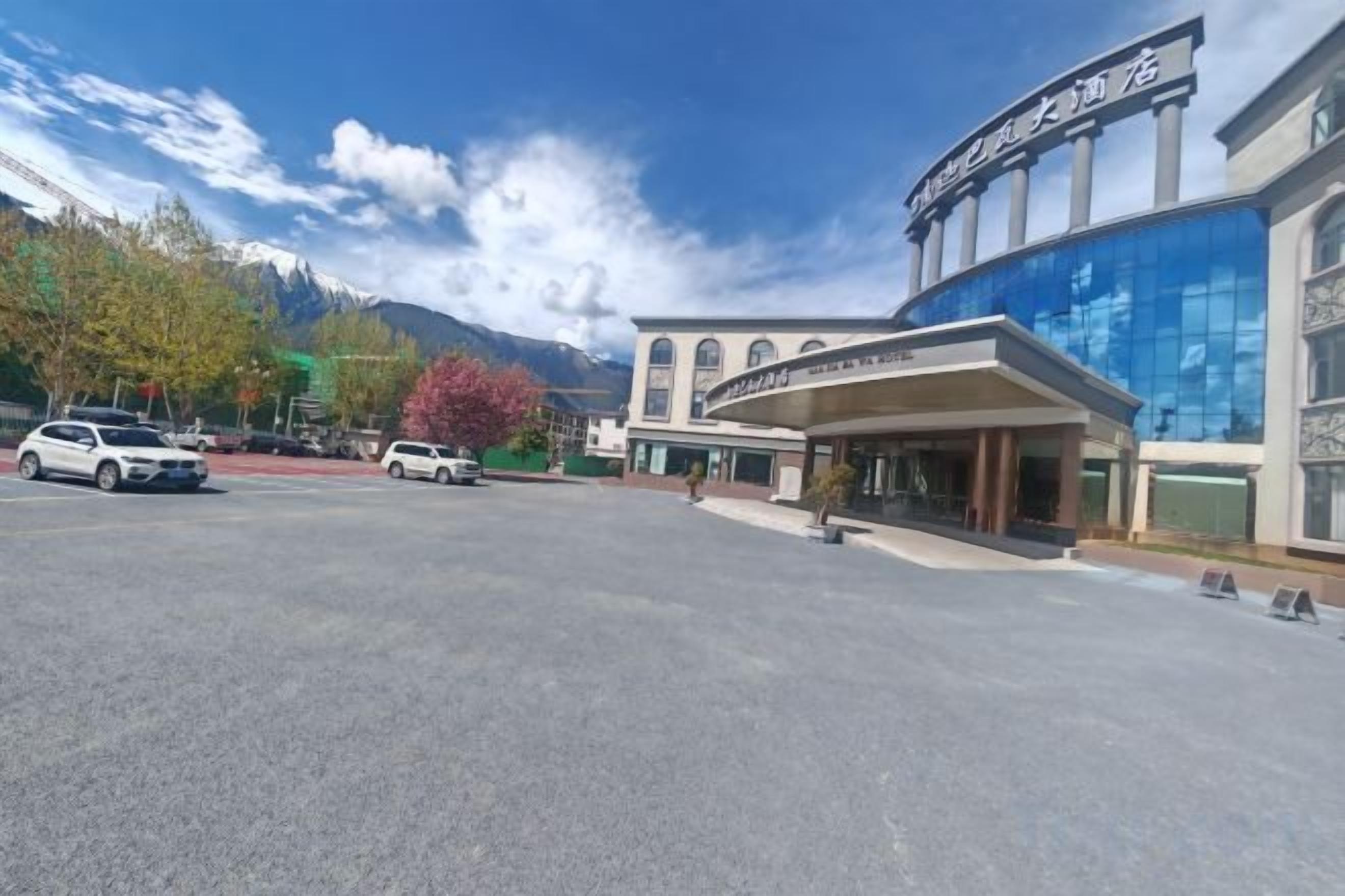 Un hôtel doté d’une façade moderne, d’une entrée couverte et offrant une vue sur les montagnes.