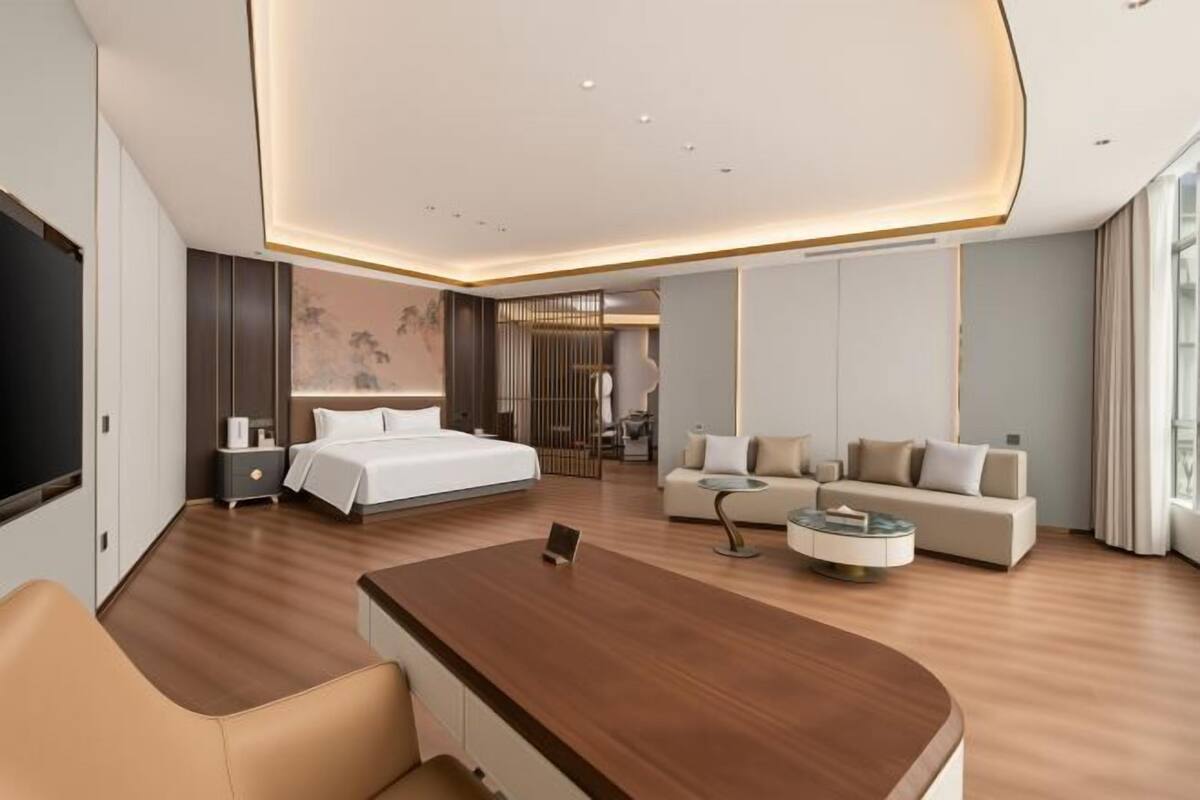 Une chambre d’hôtel moderne équipée d’un grand lit, d’un canapé, d’un bureau et d’une télévision.
