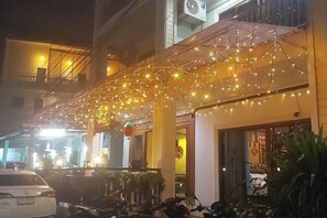 Een gebouw met een overdekt terras versierd met lichtjes.
