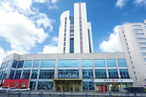 A modern building with a prominent vertical structure and a large glass facade. - Huali Hotel (Kunshan Golden Eagle International Shopping Center) (Kunshan)