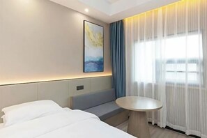 A modern hotel room with a bed, a small seating area, a round table, and a large window with sheer curtains. - Huali Hotel (Kunshan Golden Eagle International Shopping Center) (Kunshan)
