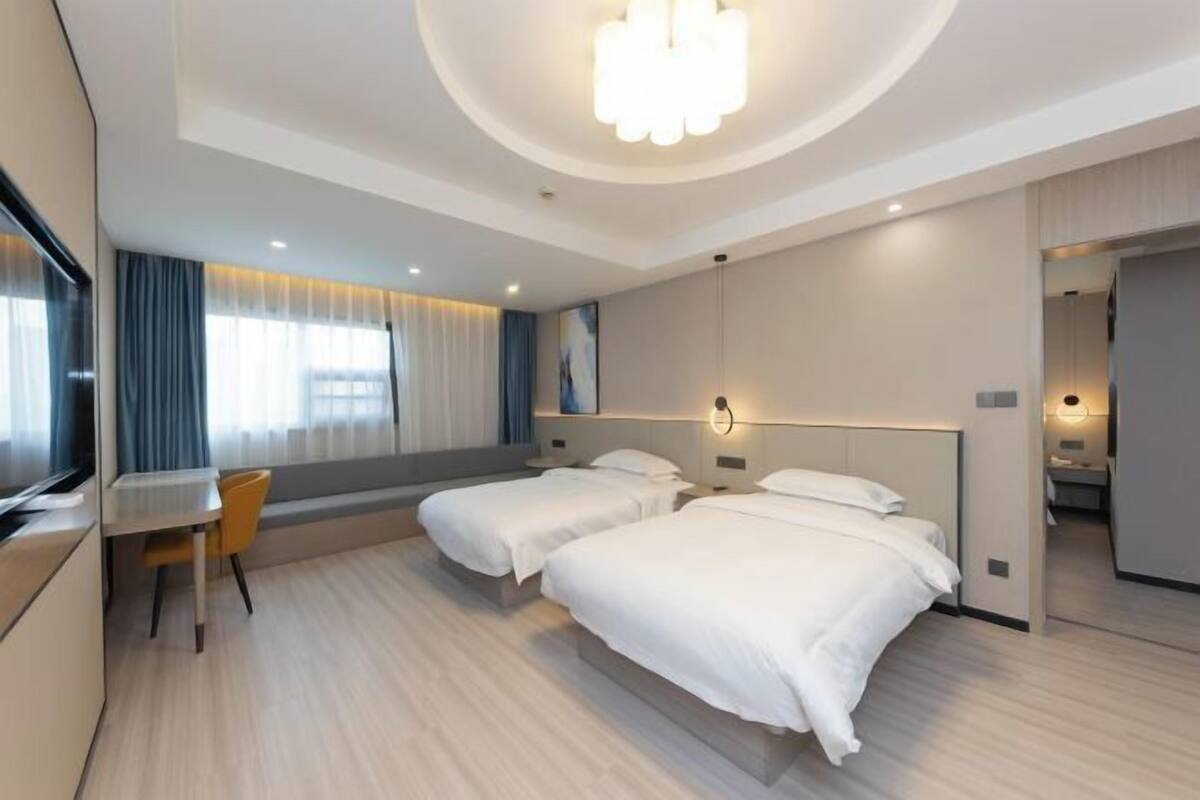Una habitación de hotel moderna con dos camas, un escritorio y una silla.