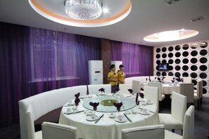 A dining area with round tables, white chairs, and purple curtains. - Great Wall Hotel (Wuyuan High-speed Railway Station) (Wuyuan)