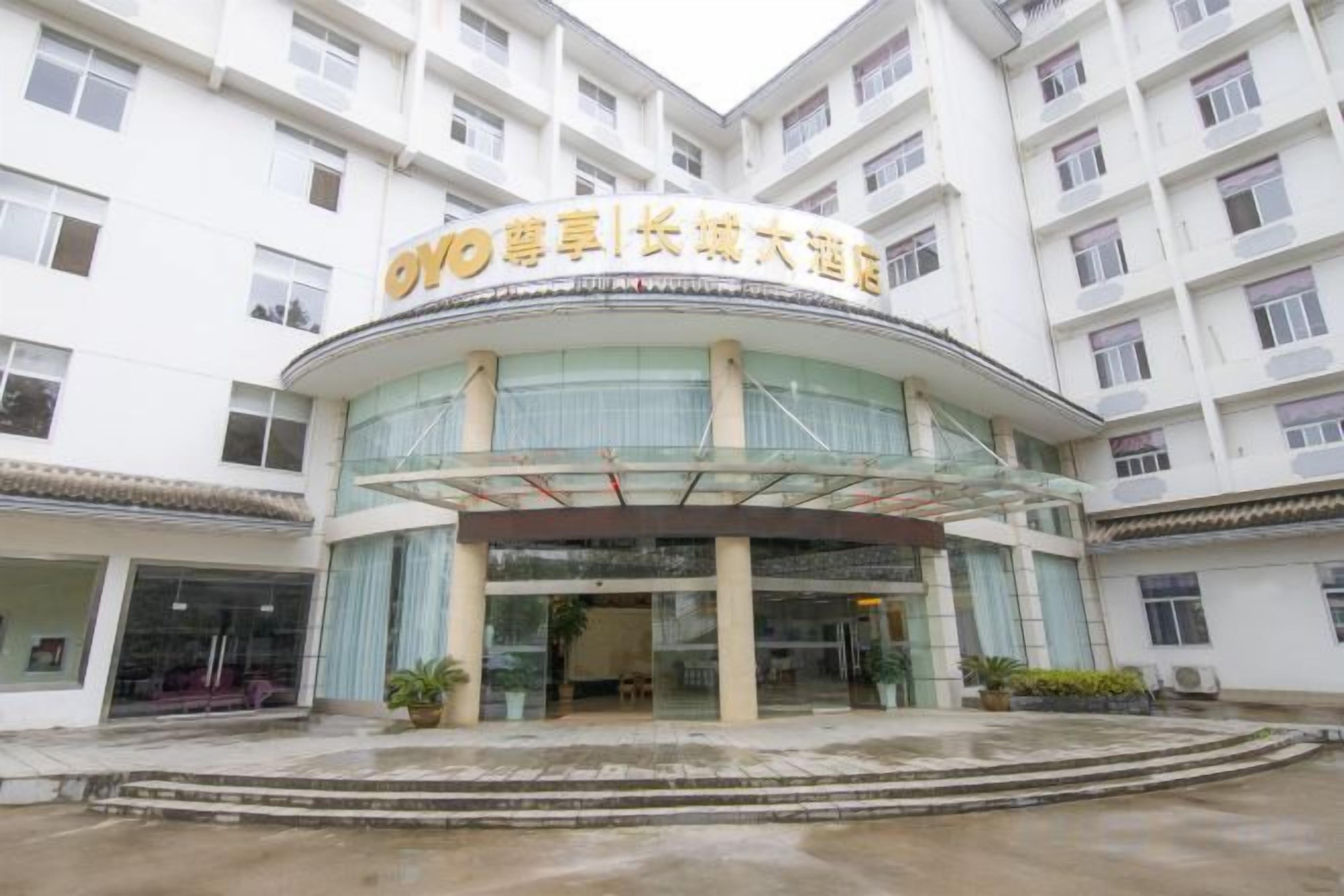 A hotel with a curved entrance, multiple floors, and a sign with Chinese characters.