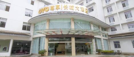 A hotel with a curved entrance, multiple floors, and a sign with Chinese characters.