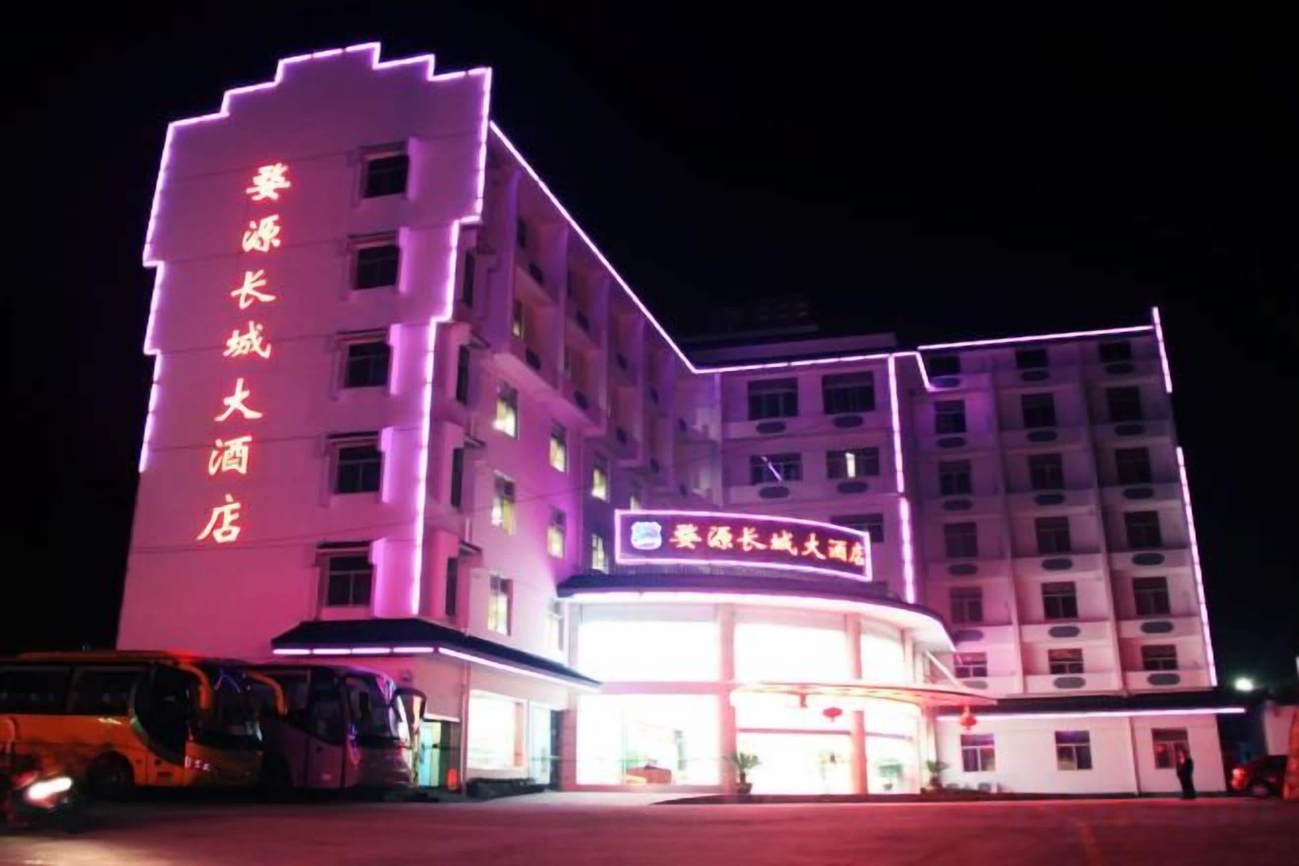 A multi-story hotel with illuminated signage and a large entrance.