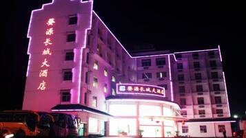 A multi-story hotel with illuminated signage and a large entrance.