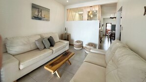 A modern living room with a beige sofa, a wooden coffee table, and a ceiling fan.