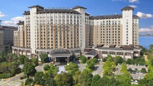 A large, multi-story hotel with a symmetrical facade, multiple balconies, and a central entrance with a covered area. - Steigenberger Nanchang Sunac (Nanchang)