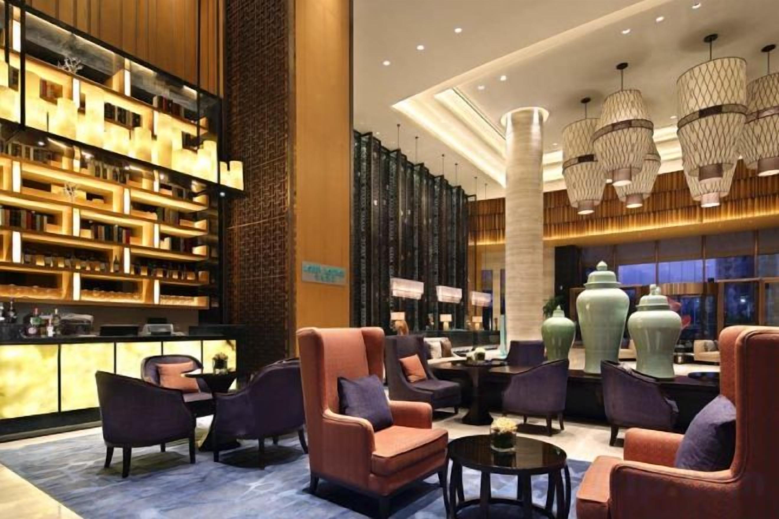 A lobby with a bar area, seating, and a large vase.