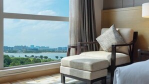 A hotel room with a large window, a chair, and a bed. - Steigenberger Nanchang Sunac (Nanchang)