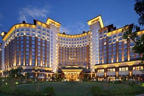 A large, multi-story hotel with a curved facade, a central courtyard, and a well-lit entrance. - Steigenberger Nanchang Sunac (Nanchang)