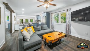 A modern living room with a gray sofa, wooden coffee table, and a ceiling fan. - Pet Friendly, Short walk to Lake Monroe (Nashville)