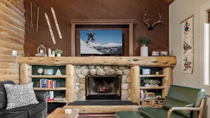 Un acogedor interior de cabaña de madera con chimenea, mobiliario de cuero y decoración temática de esquí.