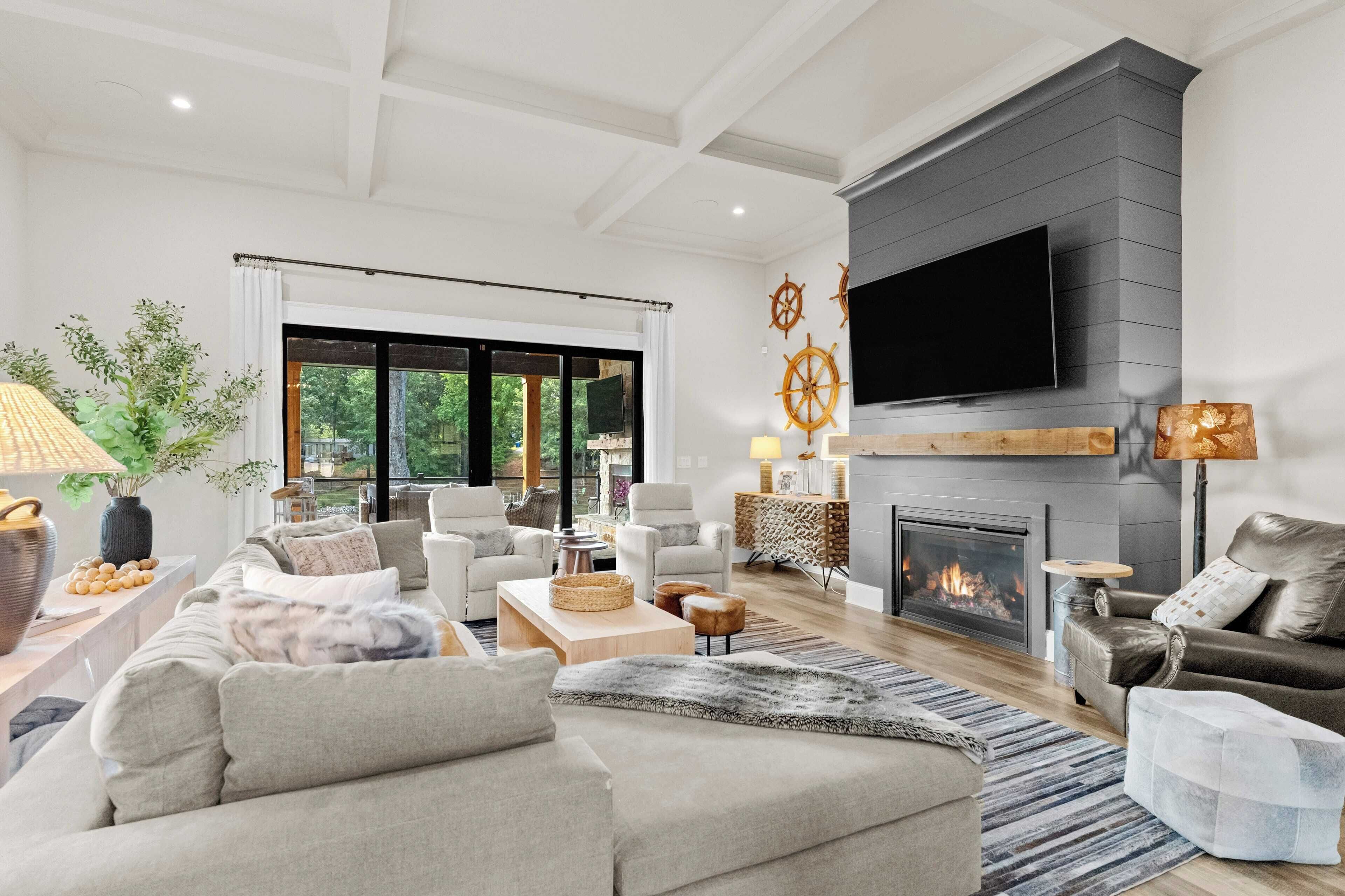 A spacious living room with a fireplace, comfortable seating, and a large TV.