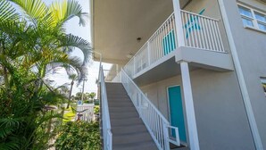 A multi-story building with a staircase leading to a balcony. - Beach Pad | Pool | Walk to the beach (Cape Canaveral)