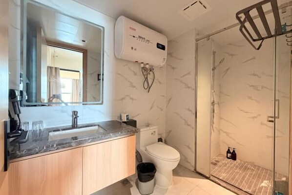 A modern bathroom with a marble sink, toilet, and shower. - Island Skylight Resort (Huidong)