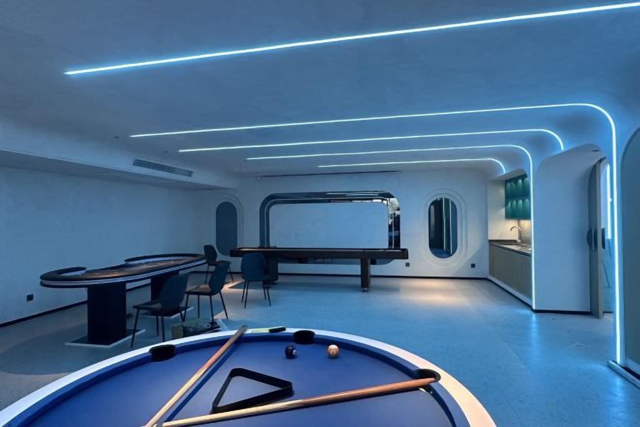 A pool table with a blue felt surface, a billiards cue, and several billiard balls.