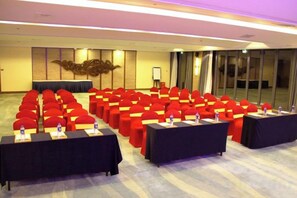 A conference room with rows of chairs and tables, a podium, and a large window. - Island Skylight Resort (Huidong)