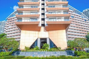 A multi-story hotel with a distinctive architectural design, featuring a central atrium and multiple balconies. - Island Skylight Resort (Huidong)