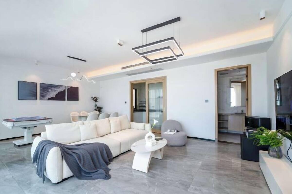 A modern living room with a sofa, coffee table, and a TV.