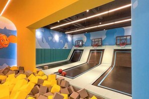 An indoor play area with foam blocks, a basketball hoop, and a wall mural. - Island Skylight Resort (Huidong)