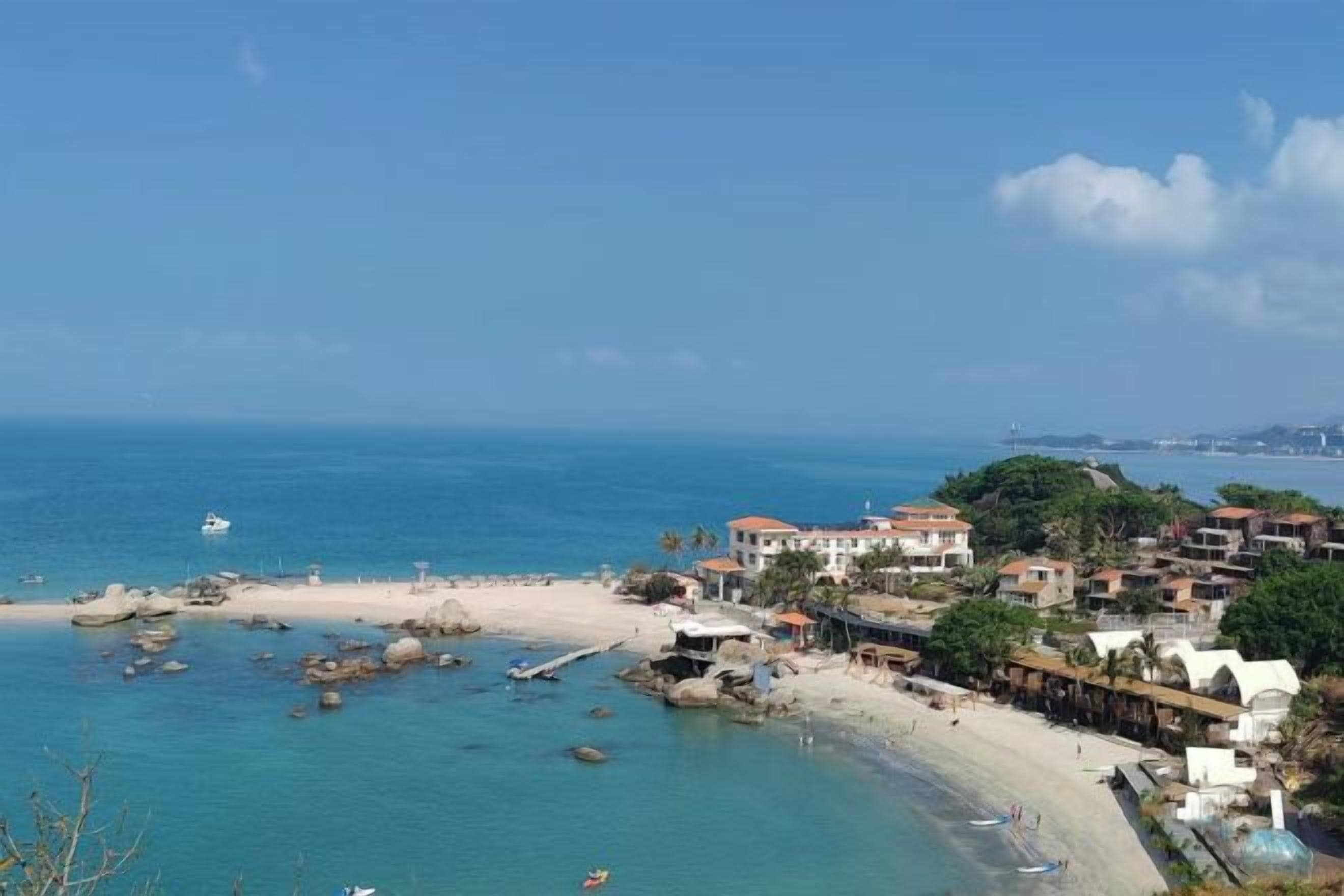 A coastal town with a beach, boats, and buildings.
