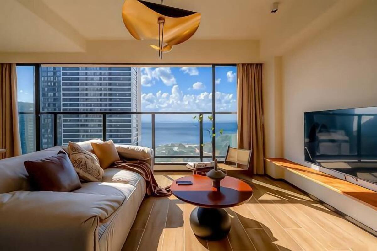 A modern living room with a sofa, a coffee table, and a TV.