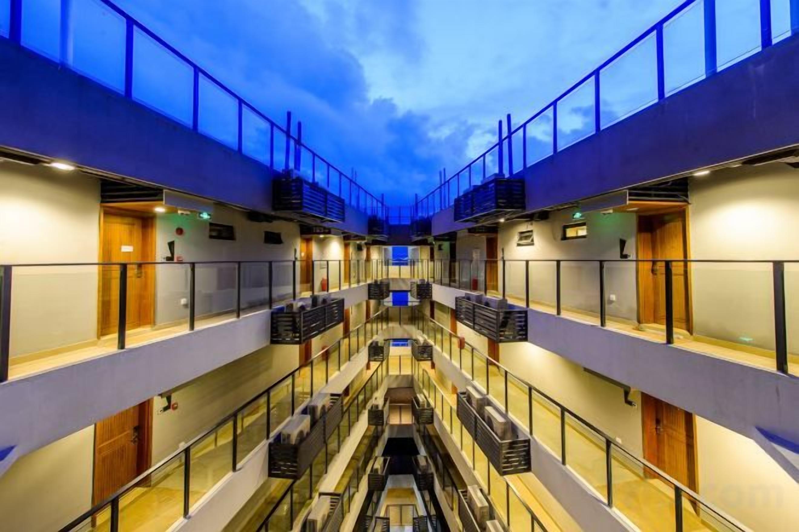 A multi-level hotel interior with balconies, staircases, and a central atrium.