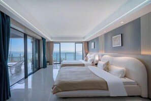 A modern hotel room with two beds, a large window with a view of the sea, and a balcony with outdoor seating. - Island Skylight Resort (Huidong)