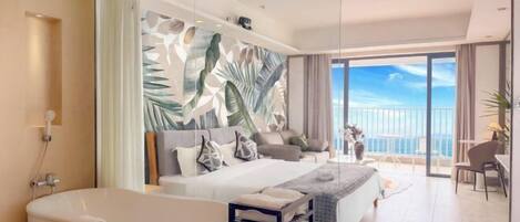 Habitación de hotel moderna con una cama grande, una bañera, un balcón con vistas y un mural temático tropical.